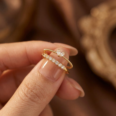 Gold ring with a diamond on a person's finger against a blurred background