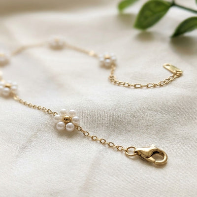 Gold bracelet with a clasp on a light fabric background